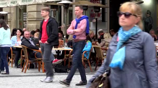 PRAGUE, CZECH REPUBLIC - MAY 30, 2015: city - urban street - sidewalk with walking people - restaurant: outdoor seating with sitting people — Stock Video