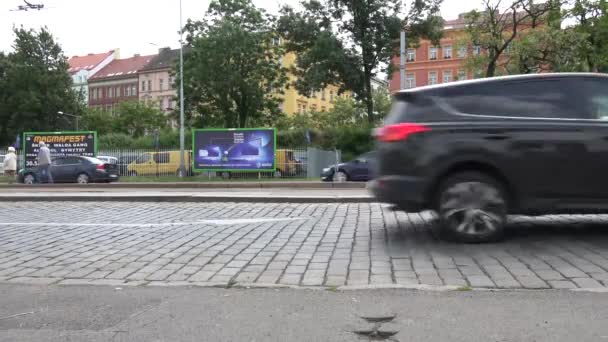 PRAGA, REPÚBLICA CHECA - 31 DE MAYO DE 2015: calle urbana con coches de paso en la ciudad - edificio con árboles en el fondo — Vídeo de stock