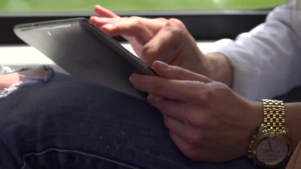 Jeune femme blonde attrayante voyageant en train et travaille sur tablette - gros plan — Video