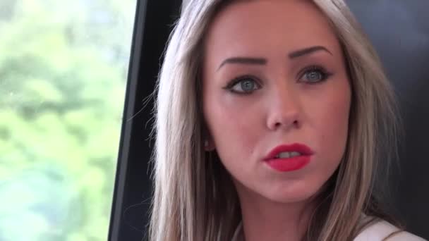 Jong aantrekkelijk blond vrouw reizen met de trein en kijkt uit het raam - close-up — Stockvideo