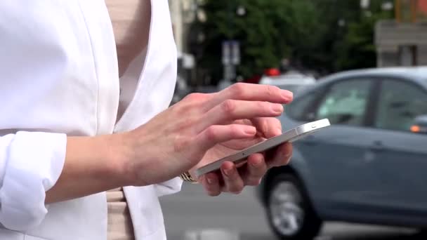 Joven mujer rubia atractiva trabaja en el teléfono inteligente - calle urbana con coches en la ciudad - primer plano — Vídeos de Stock