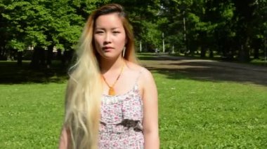 Genç ve çekici bir kadın parkta ileri geri yürüyor. Düşün.