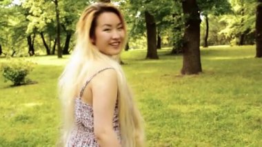 young asian attractive woman walks and shows: come here - steadicam - filter