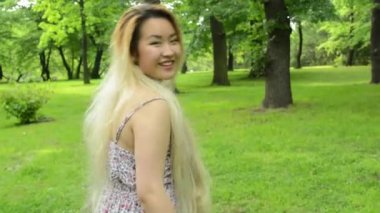young asian attractive woman walks and shows: come here - steadicam
