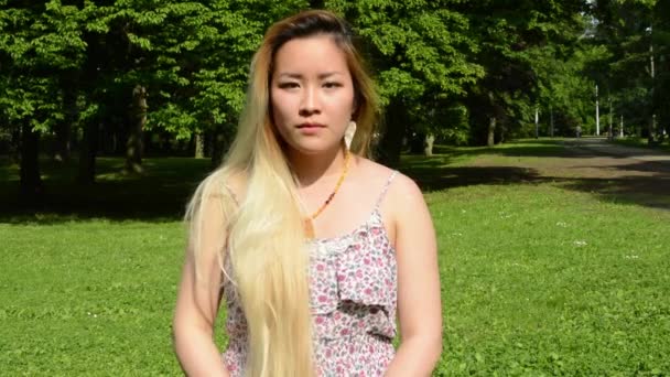 Jeune attrayant heureux asiatique femme retourne et sourit dans le parc sourire à la caméra — Video