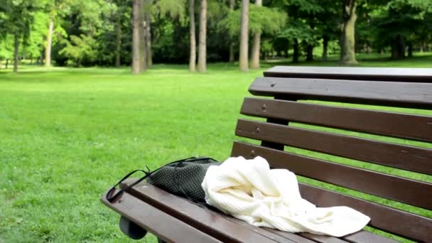 Forgotten things lies on the bench in the park - detail — Stock Video