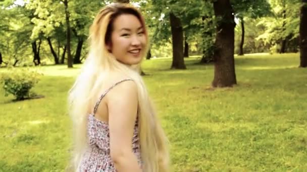 Young asian attractive woman walks and shows: come here - steadicam - filter — Stock video