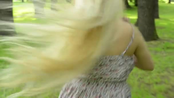 Jonge aantrekkelijke vrouw loopt in het park met los haar - steadicam - closeup — Stockvideo