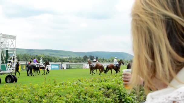 PRAGA, REPÚBLICA CHECA - 21 DE JUNIO DE 2015: carreras de caballos - los caballos se preparan para la carrera - la gente los observa — Vídeos de Stock