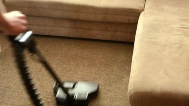 adam kanepe önce elektrikli süpürge ile halı temizler