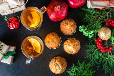 Ev yapımı kekler ve bir fincan çay Noel şenlik masası bayram kutlaması için yeni yıl partisi hazırlıyor. Hediye olarak lezzetli porsiyon servis ediliyor.