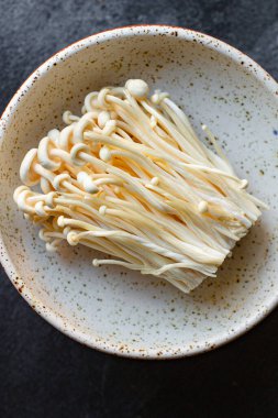 Enoki Enokitake mantarları Flammulina velutipes yenilebilir Japon Hot Pot mutfağı sağlıklı yemek malzemesi üst katman fotokopi alanı metin gıdası arka plan kırsal keto veya paleo diyeti için
