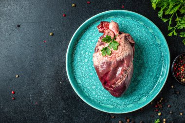 Çiğ domuz ya da sığır kalbi eti ikinci tabak aperatif masada yemeye hazır sağlıklı yemek malzemeleri üst görünüm fotokopi alanı metin gıdası arka plan kırsal keto ya da paleo diyeti için