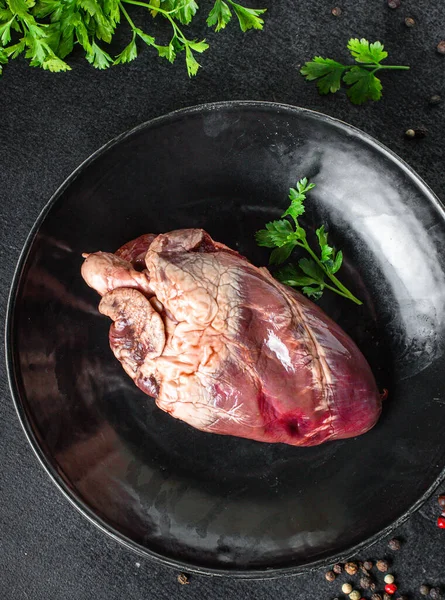 Çiğ domuz ya da sığır kalbi eti ikinci tabak aperatif masada yemeye hazır sağlıklı yemek malzemeleri üst görünüm fotokopi alanı metin gıdası arka plan kırsal keto ya da paleo diyeti için