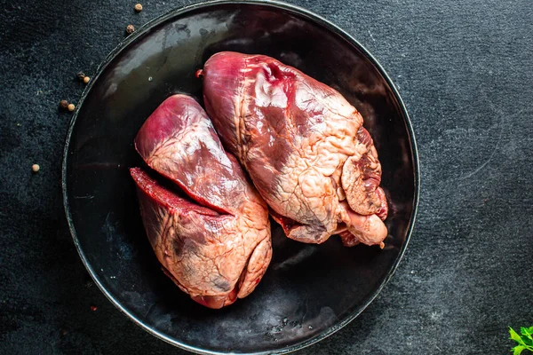 Çiğ domuz ya da sığır kalbi eti ikinci tabak aperatif masada yemeye hazır sağlıklı yemek malzemeleri üst görünüm fotokopi alanı metin gıdası arka plan kırsal keto ya da paleo diyeti için