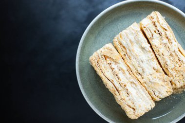 kek Napolyon puf böreği millefeuille ve tereyağı kremalı tatlı tatlı porsiyon hazır yemek ve yemek için masada hazır yemek atıştırmalık üst görünüm metin yiyecekleri arka plan kırsal görüntü için fotokopi alanı