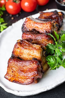 Kemikte kaburga eti parçaları ve yağlı ızgara barbekü sosu. İkinci tabak abur cubur. Masada yenmeye hazır.