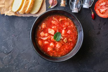 Etli taze borş kırmızı domates çorbası. Yulion ve sebzeler hazır. Sağlıklı yemek için hazır ve sofrada.