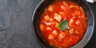 Etli taze borş kırmızı domates çorbası. Yulion ve sebzeler hazır. Sağlıklı yemek için hazır ve sofrada.