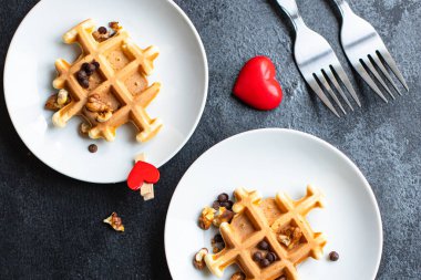İki kişilik Belçika Waffle kahvaltısı. Kalp şeklinde, arka planda, gündüz anneleri gündüz bakım evinde ya da 8 Mart 'ta metin yiyecekleri arka planı için güzel bir fotokopi alanı.