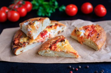 Kalın hamurlu hamur üzerine pizza fast food peyniri, domates sosu, domates ve diğer malzemeler. Masanın üzerinde sağlıklı yiyecek, açık hava atıştırmalığı. Arka plan metni için fotokopi alanı.