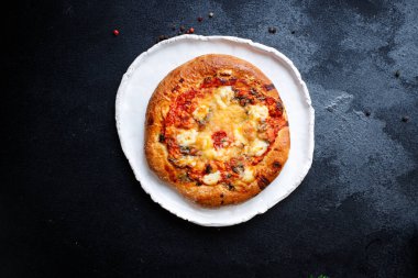 Kalın hamurlu hamur üzerine pizza fast food peyniri, domates sosu, domates ve diğer malzemeler. Masanın üzerinde sağlıklı yiyecek, açık hava atıştırmalığı. Arka plan metni için fotokopi alanı.