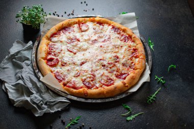 pizza pepperonisi veya salam eti sosisi ve duble peynirli fast food. Masa başında hazır yemek, açık hava manzaralı fotokopi alanı, arka plan kırsal görüntüsü için.