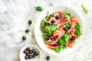 Salata, jamon, prosciutto, yeşil yapraklar, marul, zeytin, sebze, atıştırmalık sağlıklı yemek, üst yemek, fotokopi alanı, arka plan, kırsal resim, keto veya paleo diyeti.
