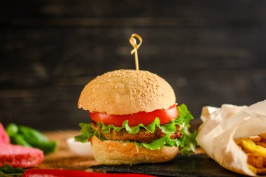 Sebzeli ve peynirli lezzetli bir burgerin yakın plan çekimi.