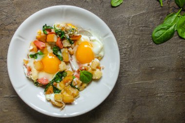 Ahşap arka planda sebzeli sahanda yumurta. en üstteki görünüm.
