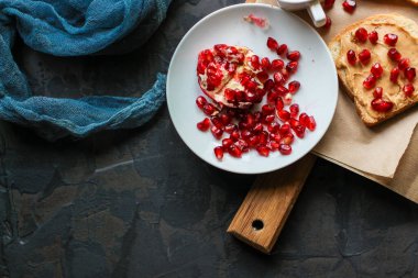 Tahtada fıstık ezmeli ve nar tohumlu lezzetli sandviçlerin yakın plan görüntüsü.