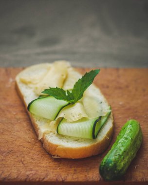 Gri arka planda salatalıklı ve peynirli sandviçler. yakın plan