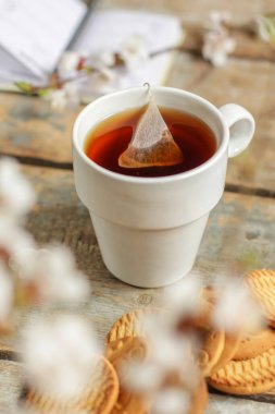 Ahşap masa arkasında bir fincan çay, yakın çekim manzarası.