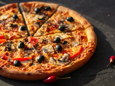 Siyah arka planda pepperonili pizza, domates, peynir, mantar ve zeytin. en üstteki görünüm.