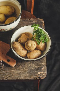Köy arka planında olgun patatesleri yakın.