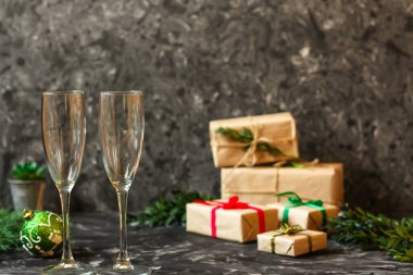 Noel arkaplanı, hediye kutuları ve karanlık bir masada gözlük..