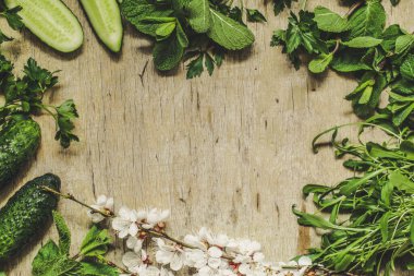 Tahta arka planda taze yeşil sebzeler ve bitkiler. Üst Manzara. Metin için boş alan.