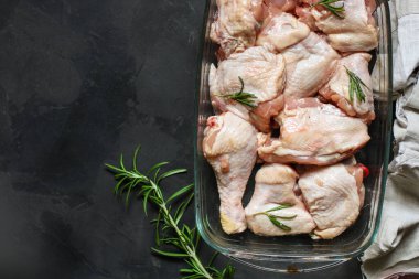 Siyah arka planda baharatlı ve otlu çiğ tavuk. yakın çekim görünümü.