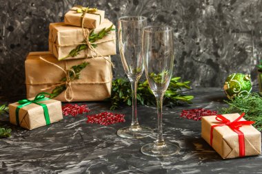 Noel arkaplanı, hediye kutuları ve karanlık bir masada gözlük..