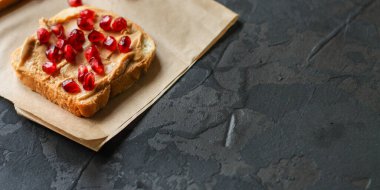 Tahtada fıstık ezmeli ve nar tohumlu lezzetli sandviçlerin yakın plan görüntüsü.