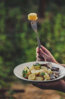 Tahta masada kaşık ve bıçakla çatal tutan kadınların ellerini kapatın.