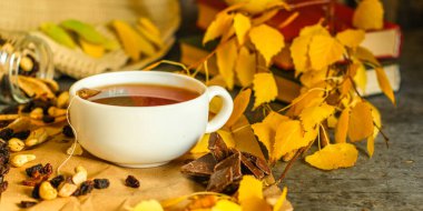 Sonbahar yapraklarında çikolata parçaları olan çay.