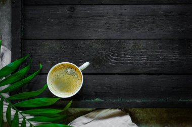 Koyu ahşap arka planda bir fincan kahve.