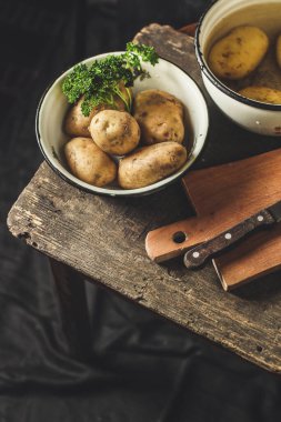 Köy arka planında olgun patatesleri yakın.