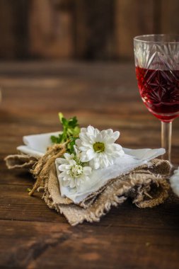 Kandilli beyaz şarap ve ahşap arka planda kırmızı güller.