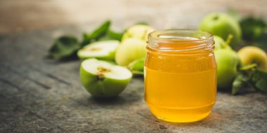 Cam kavanozda ballı olgun elmalar.