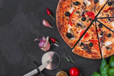 Siyah arka planda pepperonili pizza, domates, peynir ve fesleğen. en üstteki görünüm. 
