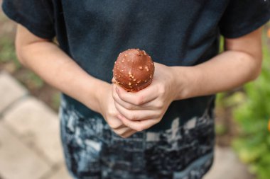 Çikolatalı dondurma külahı tutan kişi.