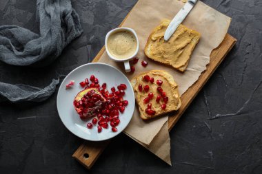 Tahtada fıstık ezmeli ve nar tohumlu lezzetli sandviçlerin yakın plan görüntüsü.