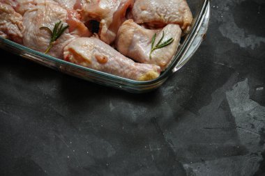 Siyah arka planda baharatlı ve otlu çiğ tavuk. yakın çekim görünümü.